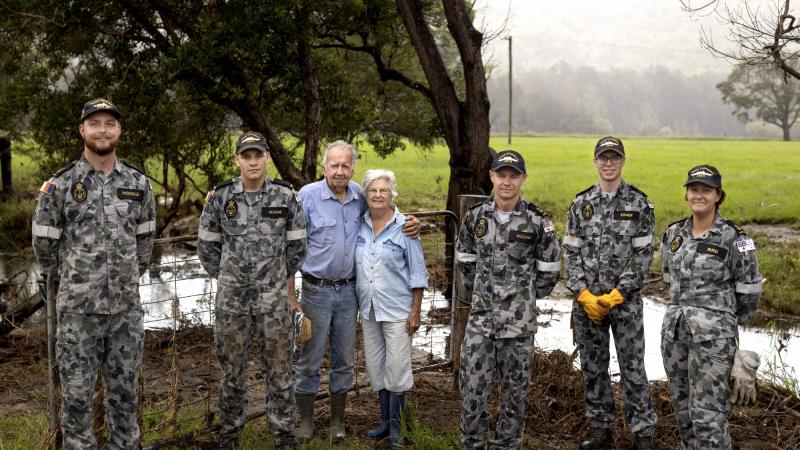 Sailors with Neil and Gwen Mcleod after clearing debris from their flood-damaged property in Scotts Head, NSW. Photo: Corporal Robert Whitmore