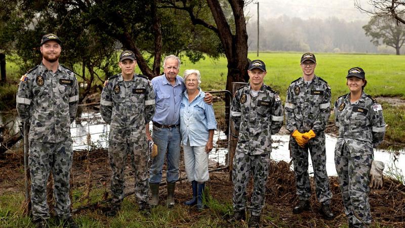 Navy sailors with Neil and Gwen Mcleod after clearing debris from their flood damaged property in Scotts Head, NSW. Photo: Corporal Robert Whitmore