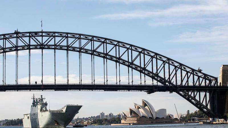 HMAS Adelaide sails under the Sydney Harbour Bridge. Photo: Tara Morrison