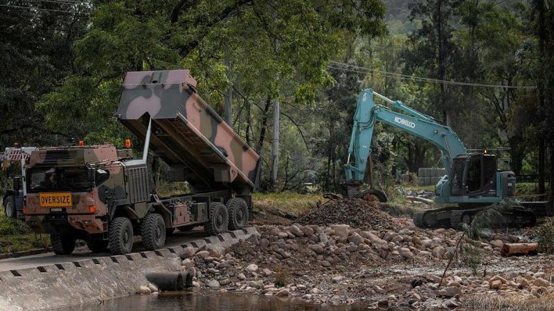 An Army HX77 and excavator being used to reconstruct a bridge near Wauchope, NSW, which was damaged by the floods. Photo: Private Jacob Hilton