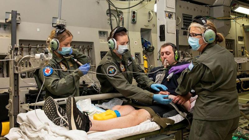 Corporal Kate Fox, left, Sergeant Fiona Jackson and Flight Lieutenant Susan Coretti treat a simulated patient during an Aeromedical Evacuation Training Exercise on board a C-17 Globemaster III. Photo: Leading Aircraftwoman Emma Schwenke