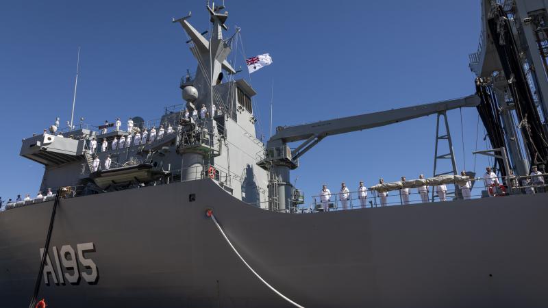 The crew of HMAS Supply lines the upper decks at the end of her commissioning ceremony at Fleet Base East in Sydney. Photo: Sergeant Cameron Pegg