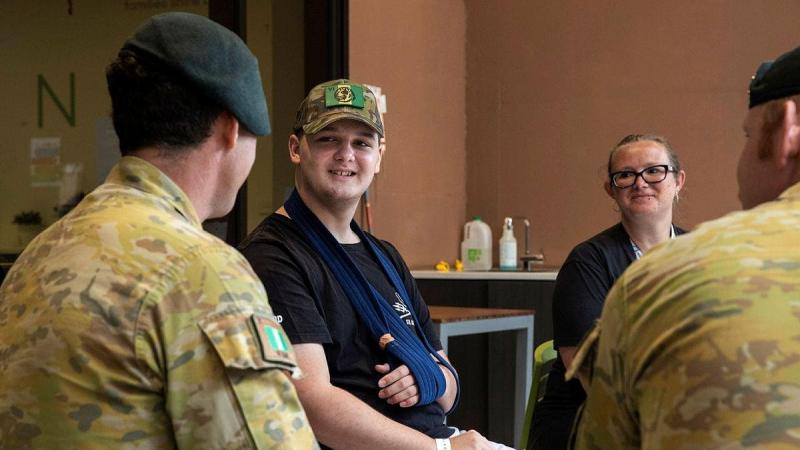 Corporal Brenton Munro, left, from the 6th Battalion, Royal Australian Regiment, talks with 14-year-old Knox Scott and his mother Lauren at Ronald McDonald House, South Brisbane. Photo: Corporal Nicole Dorrett
