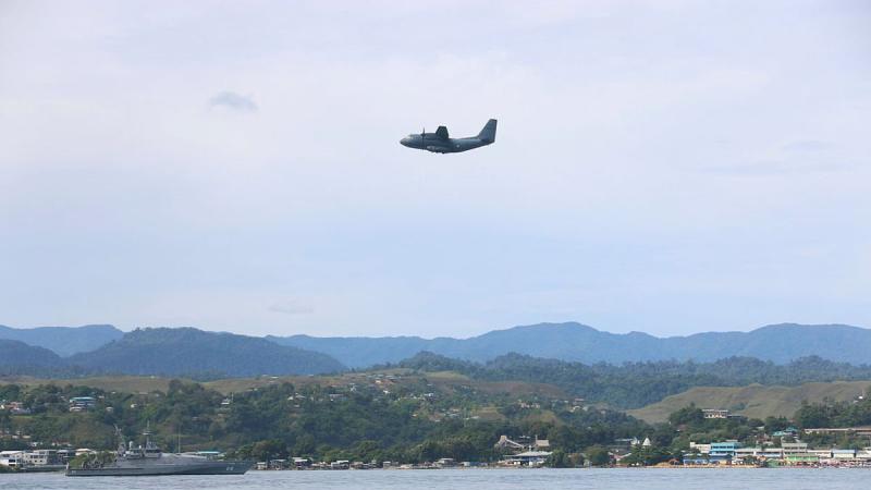 An Air Force C-27J Spartan flies over HMAS Maitland off the coast of Honiara, Solomon Islands, during Operation Solania. Photo: Seaman Isaiah Appleton
