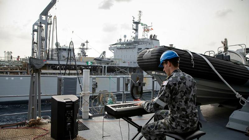 Able Seaman Xavier Riddell plays the keyboard during a replenishment at sea with HMAS Sirius in the Bay of Bengal. Photo: Leading Seaman Thomas Sawtell