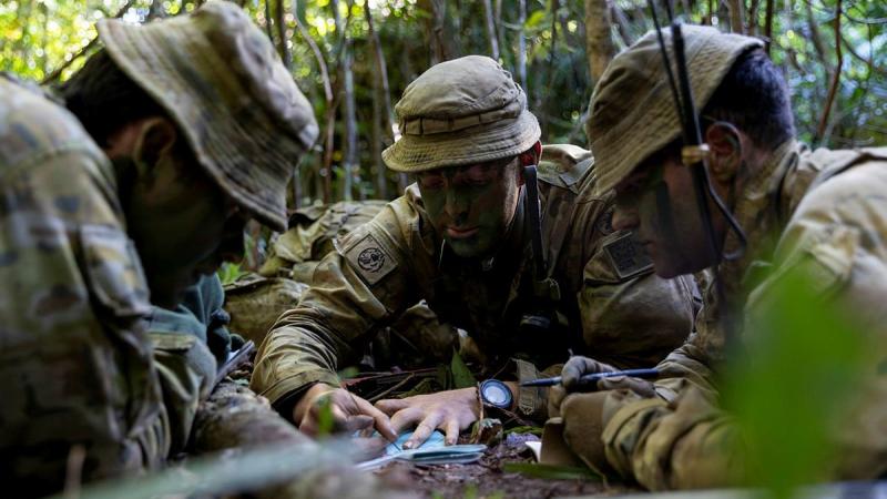 Lieutenant David Adams, centre, from the 6th Battalion, Royal Australian Regiment, briefs Major David Hodge, left, at the Combat Training Centre - Jungle Training Wing, Tully, Queensland. Photo: Corporal Brodie Cross