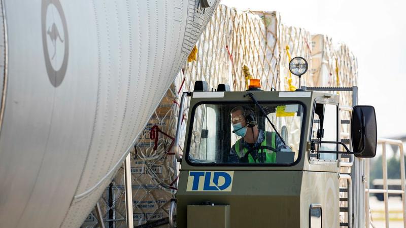 An Air Movements Operator from No. 23 Squadron load pallets of AstraZeneca vaccine and COVID-19 medical supplies bound for Fiji onto a C-130J Hercules, at RAAF Base Amberley. Photo: Leading Aircraftwoman Emma Schwenke