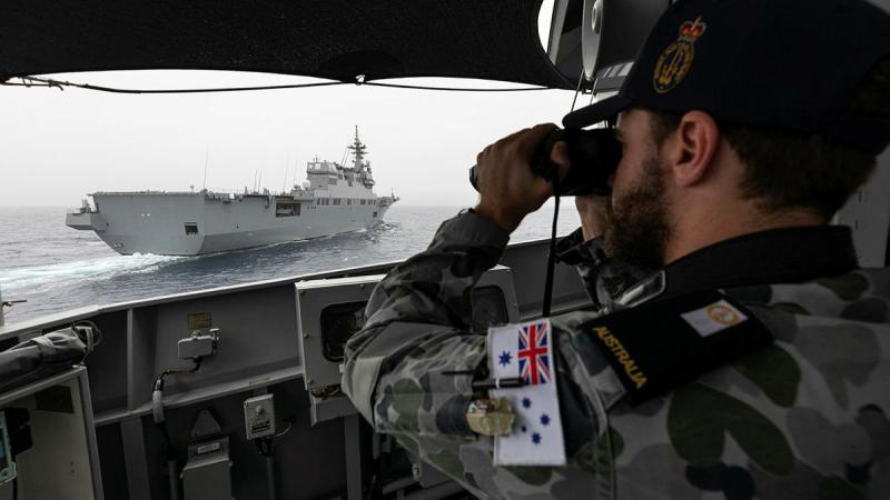 Midshipman Thomas Armstrong checks HMAS Parramatta's distance from Japan Maritime Self-Defense Force vessel JS Ise with laser range-finding binoculars during Exercise ARC21. Photo: Leading Seaman Jarrod Mulvihill