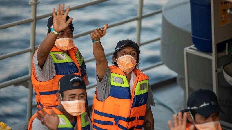 Rescued Indonesian fishermen wave goodbye to the crew of HMAS Anzac from the Indonesian Navy patrol vessel KRI Escolar following their return to Bali. Photo: Leading Seaman Thomas Sawtell