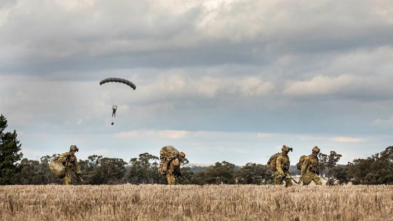 Soldiers from 2 Commando Regiment depart the drop zone after parachuting into crop fields in Temora, NSW. Photo: Sergeant Janine Fabre