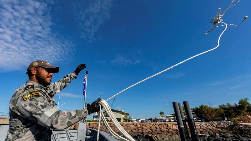 Able Seaman Lancaster Mara casts a line from the forecastle of HMAS Launceston alongside HMAS Coonawarra, Darwin. Photo: Leading Seaman Shane Cameron
