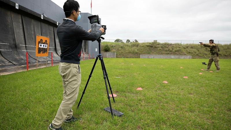 Jack Liang, an electronics engineer from the University of Sydney, trials a neuromorphic camera to capture shots fired by Leading Aircraftman Connor Fergusson at RAAF Base Richmond's 25m weapons range. Photo: Corporal Kylie Gibson