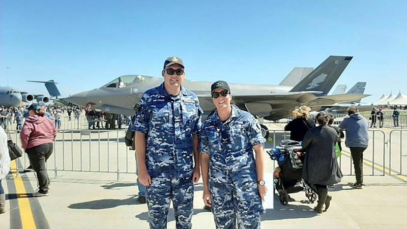 Leading Aircraftman Will Pinkerton and Leading Aircraftwoman Kate King stand in front of an F-35A Lightning II aircraft at Avalon Air Show, Victoria.