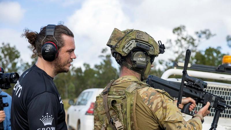 Captain Declan James explains the workings of an EF88 Austeyr Rifle to former South Sydney Rabbitoh player Ethan Lowe during his visit to Shoalwater Bay Training Area, Queensland. Photo: Corporal Nicole Dorrett