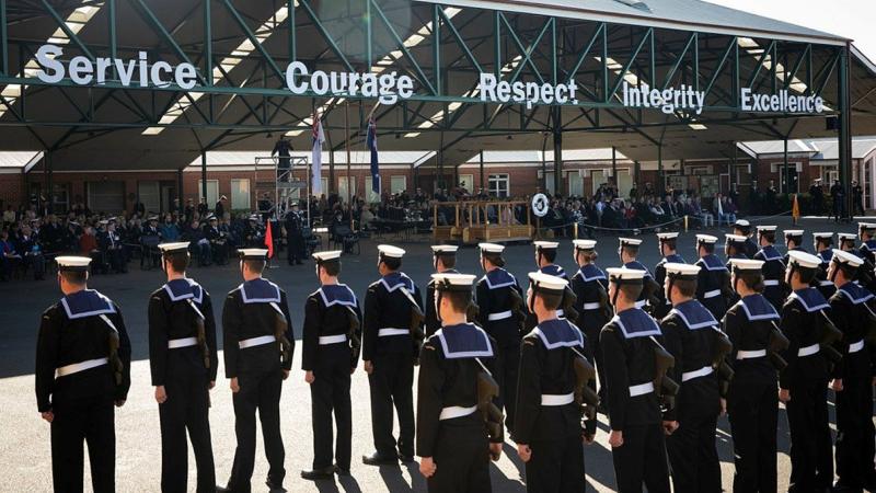 Members of General Entry 388 Emms Division standing at ease during their graduation parade at the Navy Recruit School at HMAS Cerberus, Victoria, with family and friends in the background. Photo: Leading Seaman Bonny Gassner