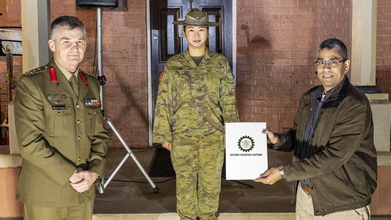 Reservist Private Izzy Kim, centre, with her civilian employer, manager Digital Analytics and Business Enablement at HCF Australia Hari Somayajula receiving a certificate of appreciation from Brigadier Mick Garraway. Photo: Corporal Dan Pinhorn