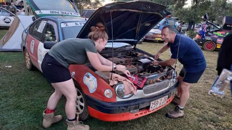 Major Lee Sankey and his daughter, Lydia, make some quick repairs to their vehicle during some down time in the Shitbox Rally.