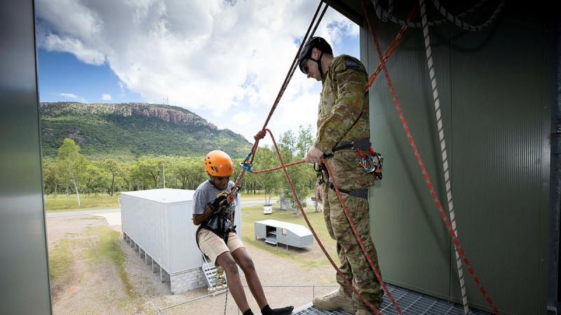 Lance Corporal Jordan Blake assists a participant of the Townsville Fire Youth Engagement Program during resilience activities at Lavarack Barracks. Photo: Corporal Brandon Grey 