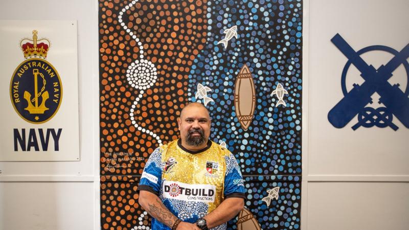 Indigenous artist Garry Purchase with one of his murals. Photo: Able Seaman Lucinda Allanson