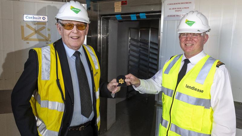 Commanding Officer HMAS Cerberus Captain Ainsley Morthorpe, right, presents Joe Alexander with a butchers rate badge during his visit to the old butchers shop at Cerberus. Photo: Leading Seaman James McDougal