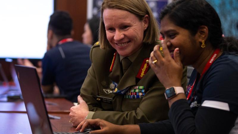 Head Information Warfare Major General Susan Coyle, CSC, DSM (left) meets with Australian Defence Force Cyber Gap Program participant Shobita during a "capture the flag" cyber skills challenge