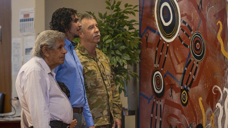 Indigenous Elder Uncle Desmond Sandy, left, artist Christopher McGregor-Sandy and Warrant Officer Class One Geoffrey Frew view the painting presented to the sergeants' mess at Gallipoli Barracks. Photo: Corporal Nicole Dorrett