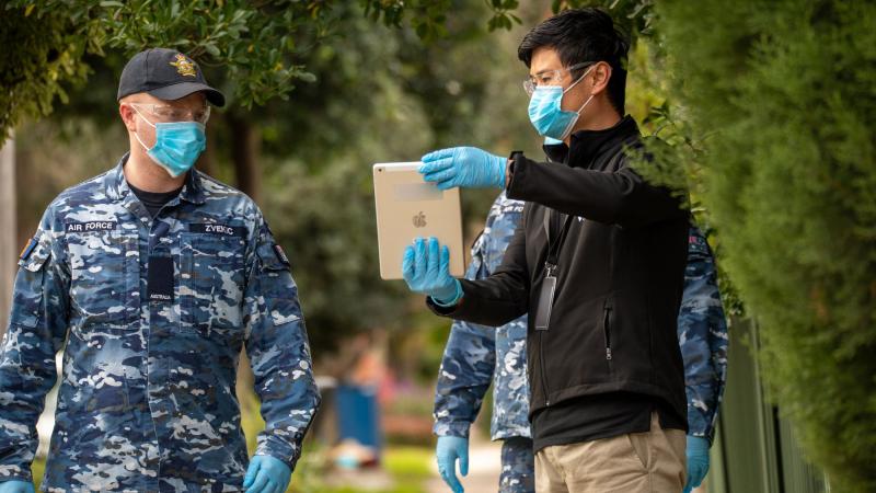 RAAF member Aircraftman Nicolas Zvekic supports Victorian Government Department of Health officer Kevin Xu to conduct Household Engagement visits in Victoria. Photo: Private Michael Currie
