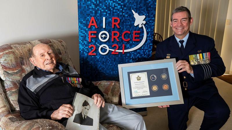 Senior ADF Officer RAAF Base Amberley Group Captain Iain Carty presents Air Force veteran Bill Heatherill with an Air Force 2021 commemorative memento in celebration of his 100th birthday. Photo: Corporal Jesse Kane