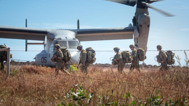 Australian Army soldiers carry their gear off a landing zone during Exercise Crocodile Response at Point Fawcett, Northern Territory.
