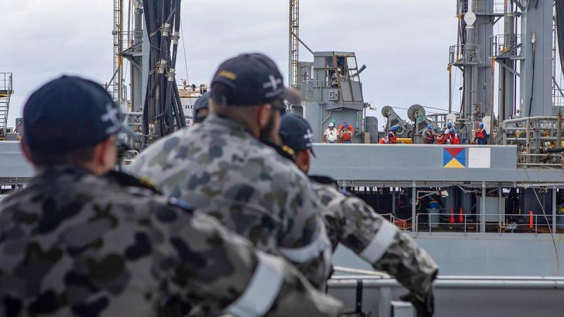 HMAS Ballarat's Ship's Company heave in a messenger line during a replenishment at sea with USNS Big Horn. Photo: Leading Seaman Ernesto Sanchez 