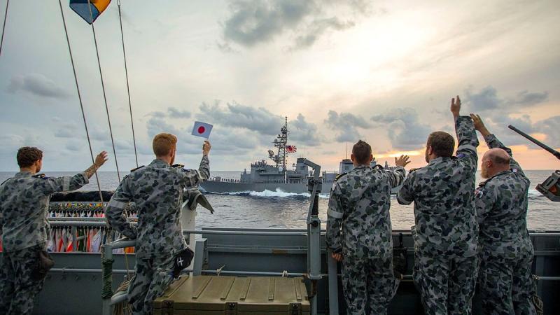 HMAS Ballarat's ship's company wave farewell as Japan Maritime Self-Defense Force Ship Murasame passes by after completing training together. Photo: Leading Seaman Ernesto Sanchez