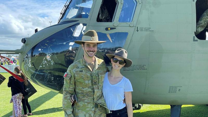 Lance Corporal Brendan Cox and his partner, Holly Fowler, stand in front of an Australian Army CH47F Chinook helicopter. 