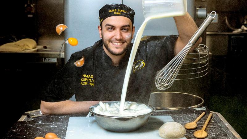 HMAS Supply chef Able Seaman Kieran Nieves prepares food in the galley on board HMAS Supply. Photo:  Able Seaman Sittichai Sakonpoonpol (Image has been digitally altered)