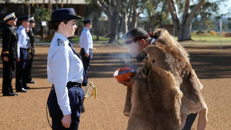 Pilot Officer Christina Way participates in a traditional smoking ceremony conducted by Whadjuk Elder Barry Winmar during the No. 261 Advanced Pilot Course Graduation at RAAF Base Pearce, WA. Photo: Chris Kershaw