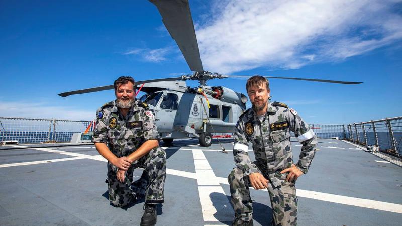 Petty Officers Andrew Booth, left, and Patrick Williams, from 816 Squadron's Flight 3 crew, with HMAS Ballarat's embarked MH-60R. Photo: Leading Seaman Ernesto Sanchez