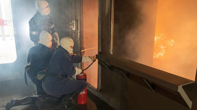 Participants in the Defence Work Experience Program are instructed how to use fire extinguishers in the School of Ship Safety and Survivability fire simulator during a visit to HMAS Cerberus. Photo: Leading Seaman James McDougall