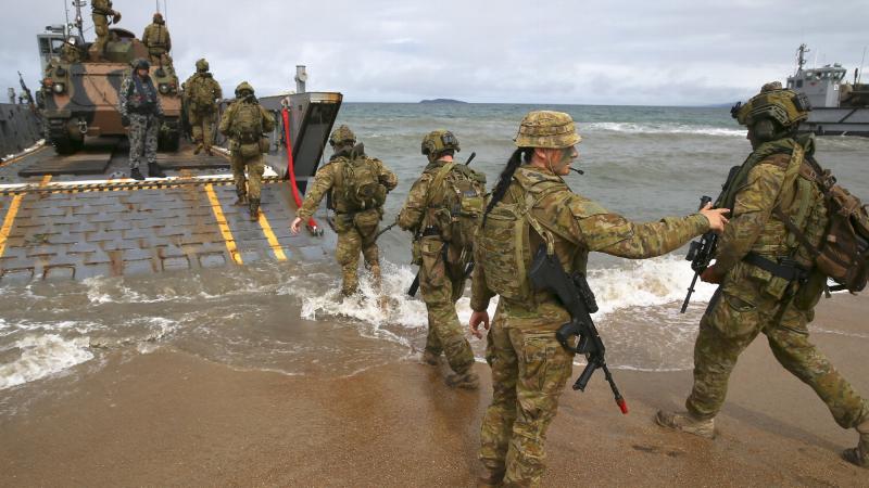Army soldier Private Alex Salter counts soldiers embarking on a landing craft about to leave Cowley Beach during Exercise Sea Explorer. Photo: Warrant Officer Class 2 Max Bree