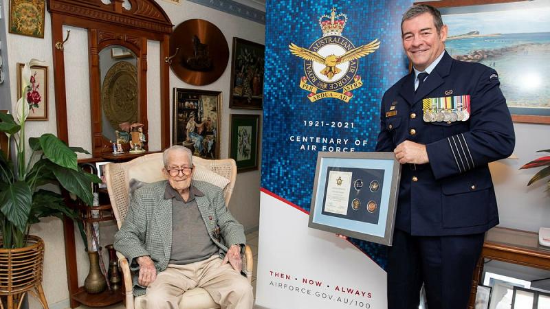 Senior ADF Officer RAAF Base Amberley Group Captain Iain Carty presents Air Force veteran Kevin Statham with an Air Force 2021 commemorative memento. Photo: Leading Aircraftwoman Emma Schwenke