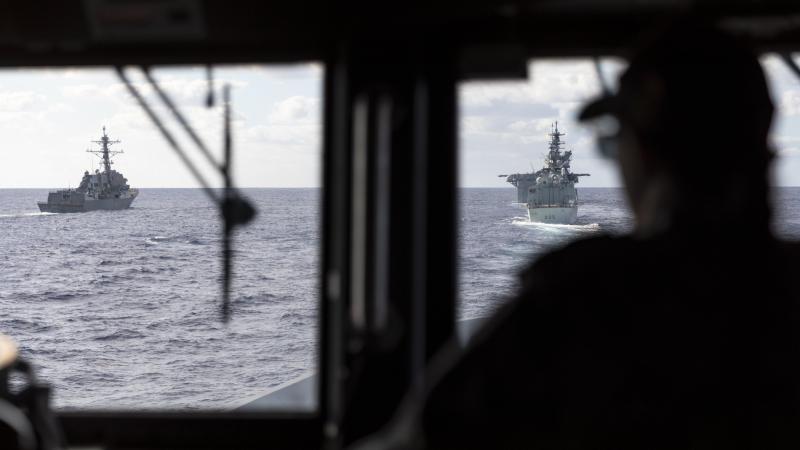 HMAS Brisbane’s Navigating Officer, Lieutenant Marita Knack, looks on as the ship sails astern of (L to R) USS Rafael Peralta, USS America and HMCS Calgary off the coast of QLD, during Exercise Talisman Sabre 2021. Photo: Leading Seaman Daniel Goodman