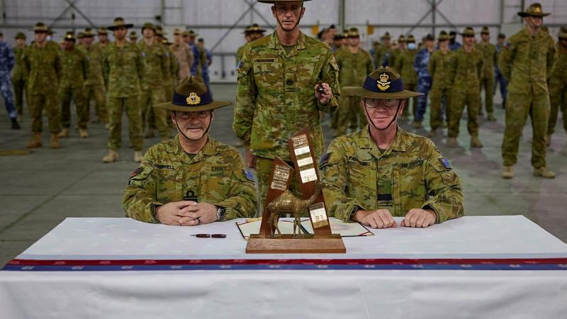 Rear Admiral Michael Rothwell, left, and Air Commodore David Paddison, right, after signing the Transfer of Authority for Command of Joint Task Force 633, witnessed by Warrant Officer Class One Mark Retallick. Photo: Sergeant Andrew Sleeman