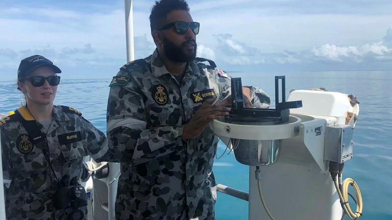 Leading Seaman Benyam Gormiesa conducts ship-handling exercises under the watch of Lieutenant Mollie Burns in ADV Cape Inscription.
