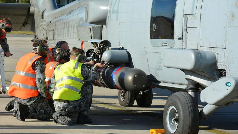 No. 816 Squadron Flight 7 maintenance team re-arms MH-60R helicopter Tiger 14 with a torpedo during the anti-submarine warfare phase of Exercise Tigerfish.