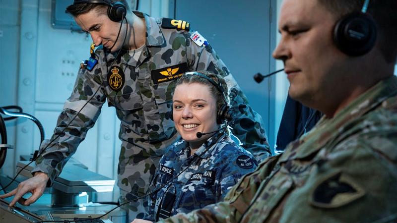 US Army’s Chief Warrant Officer 2 Robert Schenk, right, Air Force’s Flight Lieutenant Rebekah Johnson-Costigan and Navy’s Lieutenant Michael Van Den Berg in HMAS Brisbane's operations room. Photo: Leading Seaman Daniel Goodman