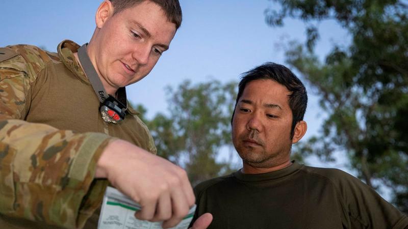 Army linguist Lance Corporal Cameron Murdoch talks with Japan Ground Self-Defense Force soldier Sergeant First Class Shigeyuki Azuma during Exercise Southern Jackaroo. Photo: Private Jacob Joseph 