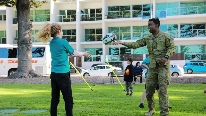 Lance Corporal Aaron Gerard, of the 7th Battalion, Royal Australian Regiment, plays football with a member of the Victor Harbor community during NAIDOC Week celebrations. Photo: Private Saar Hayon