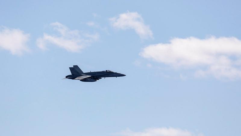 A Royal Australian Air Force FA-18A Classic Hornet aircraft approaches HMAS Brisbane during an air-warfare serial, off the coast of Queensland during Exercise Talisman Sabre 2021. Photo: Leading Seaman Daniel Goodman