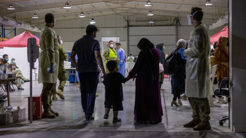    Evacuees enter the evacuee handling centre at Australia’s main operating base in the Middle East, following their evacuation from Kabul, Afghanistan. (This image has been digitally manipulated).Photo: Leading Aircraftwoman Jacqueline Forrester