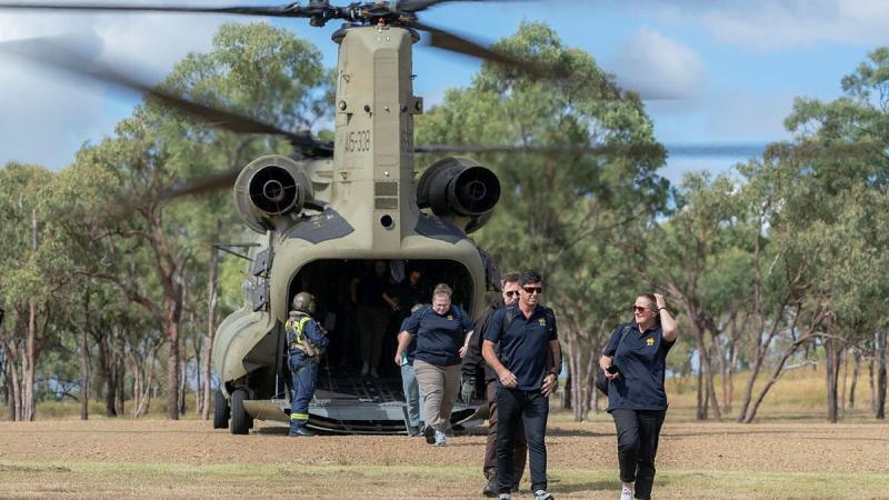 Australian Institute of Sport representatives exit a CH-47 Chinook at the Townsville Field Training Area during a visit to the Command Training Centre in Townsville, Queensland. Photo: Corporal Sagi Biderman