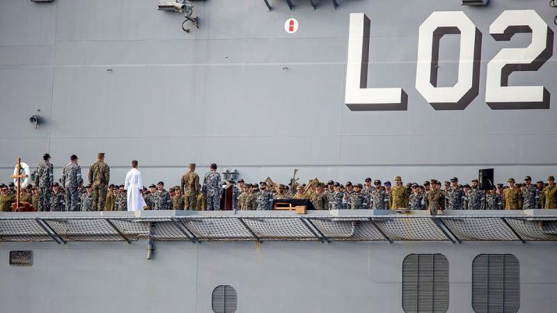 The ship's company of HMAS Canberra commemorates the 79th anniversary of the Battle of Savo Island on the flight deck while at sea in the Western Pacific. Photo: Leading Seaman Ernesto Sanchez