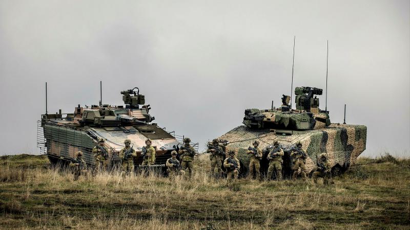 Soldiers from the 7th Battalion, Royal Australian Regiment, stand with the Hanwha Defense Australia Redback, left, and Rheinmetall Defence Australia Lynx KF-41, right, infantry fighting vehicles. Photo: Sergeant Jake Sims